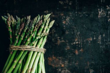 Yukardan siyah mutfak masasında taze kuşkonmaz. Süper yemek tarifi. Antika panoda organik yeşil sebze. Biyolojik gıda üretimi.