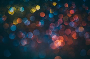 Siyah üzerine mavi, sarı ve pembe renkli Neon Bokeh arka planı. Bulanık yarım ton sanat dokusu. Bulanık gece ışıkları geçmişe dönük parlıyor. Koyu renkli daire, soyut duvar kağıdı fotoğrafçılığı..