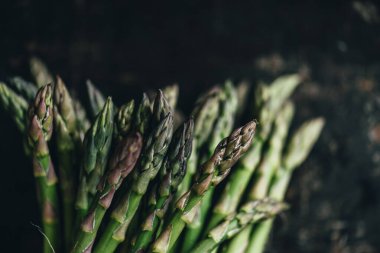 Yukardan siyah mutfak masasında taze kuşkonmaz. Süper yemek tarifi. Antika panoda organik yeşil sebze. Biyolojik gıda üretimi.