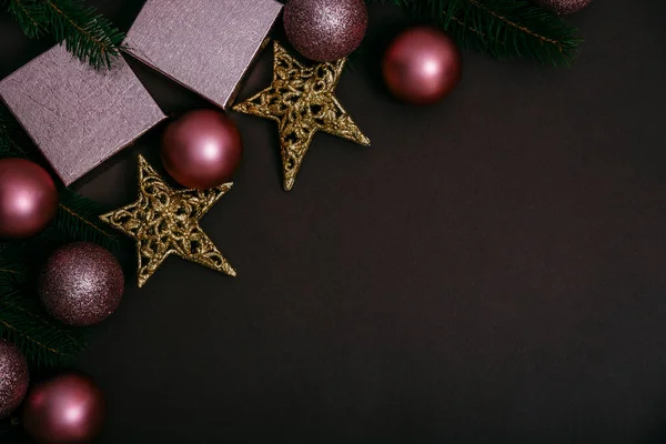 茶色の背景上のビューでピンクのクリスマスボール 光沢のあるクリスマスの泡 現在のボックスとモミの木の豪華な装飾の境界線 平置きだ 新年の最小のバラの輝きの装飾組成 — ストック写真