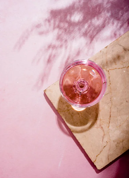 ヤシの影と豪華な大理石のテーブルの上にガラスのピンクのシャンパン トロピカルプラントシェードの質感の背景にローズワインアルコール飲料と夏のビーチカクテルパーティー トップ表示 — ストック写真