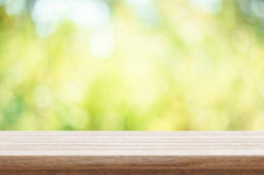Empty wooden table and green bokeh nature background. Outdoor mo