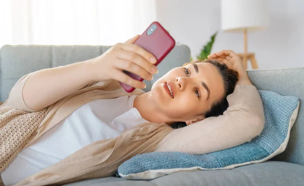 Feliz Mujer Hermosa Casual Está Utilizando Teléfono Sentado Sofá Casa — Foto de Stock