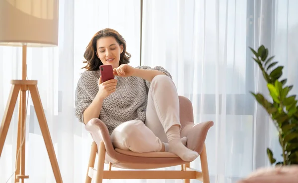 Feliz Mulher Bonita Casual Está Usando Telefone Sentado Poltrona Casa — Fotografia de Stock