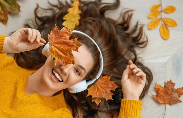 ヘッドフォンで音楽を聴いている陽気な若い女性 最上階だ 秋の雰囲気 — ストック写真