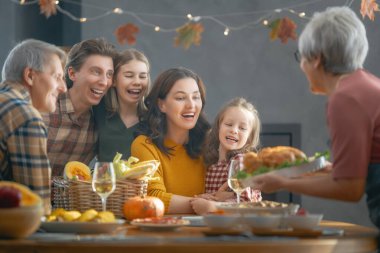 Şükran Günü, Sonbahar ziyafeti. Masada oturup bayramı kutlayan mutlu bir aile. Büyükbaba, anne, baba ve çocuklar. Geleneksel yemek..