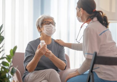 Coronavirus ve grip salgını sırasında maske takan doktor ve son sınıf öğrencisi. Virüs koruması. COVID-2019. Maske takıyor.