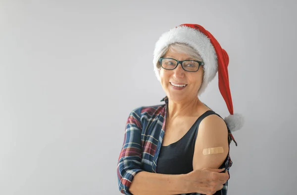 上了年纪的妇女戴着圣诞老人帽接种疫苗后 圣诞节假期的病毒防护 Covid 2019 — 图库照片