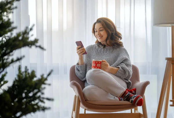 Mulher Está Usando Telefone Celular Sala Estar Decorada Para Natal — Fotografia de Stock