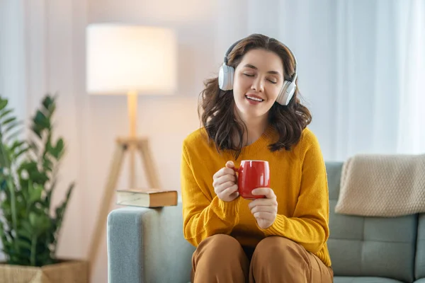 Fröhliche Junge Frau Hört Musik Über Kopfhörer Und Sitzt Hause — Stockfoto