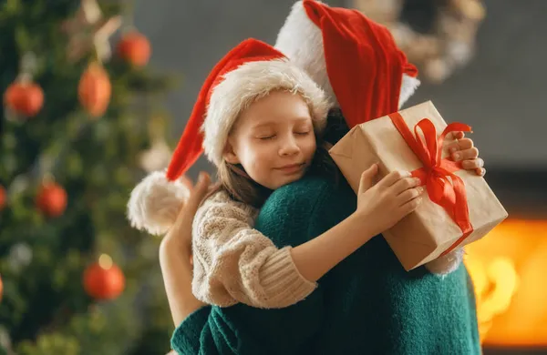 圣诞快乐 节日快乐 快乐的妈妈和她可爱的女儿交换礼物 妈妈和小孩在室内的树上玩得很开心 有礼物在房间里的爱的家庭 — 图库照片