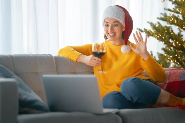 女人在装饰过圣诞节的客厅里用笔记本电脑聊天 — 图库照片