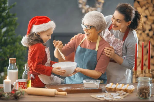 Merry Christmas and Happy Holidays. Family preparation holiday food. Grandma, mother and daughter cooking cookies.