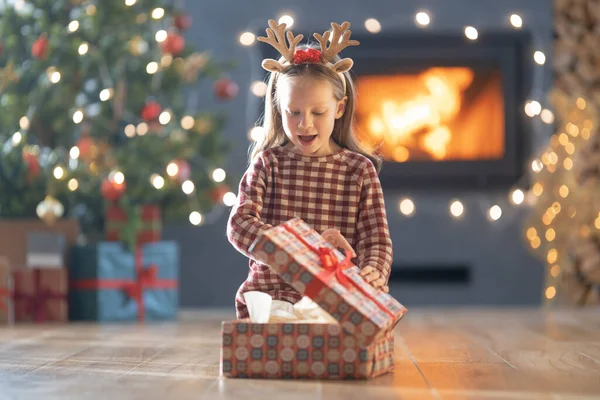 圣诞快乐 节日快乐 带着礼物快乐可爱的小女孩 小孩在树旁玩得很开心 — 图库照片