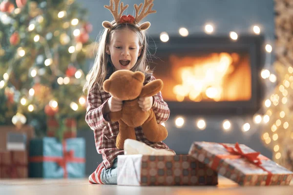 メリークリスマスとハッピーホリデー ギフト付きの陽気なかわいい子供の女の子 子供は木の近くで楽しんでいる — ストック写真