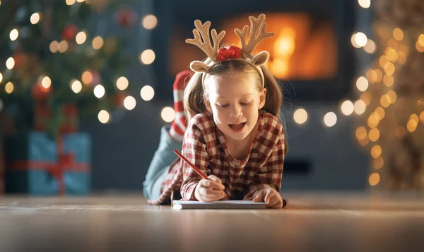 圣诞快乐 节日快乐 可爱的小女孩正在室内树上给圣诞老人写信 — 图库照片