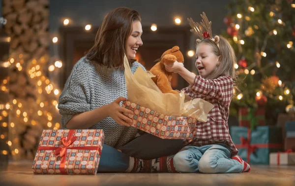 크리스마스 홀리데이 즐거운 어머니와 귀여운 선물을 교환한다 엄마와 아이들은 근처에서 — 스톡 사진