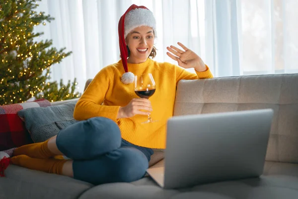 女人在装饰过圣诞节的客厅里用笔记本电脑聊天 — 图库照片