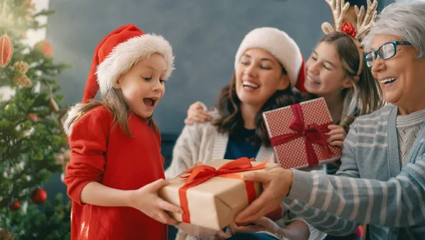 メリークリスマスとハッピーホリデー ママとおばあちゃんへの贈り物を提示する陽気な子供 屋内で木の近くで遊んでいる親と小さな子供 プレゼント付きの家族を愛する — ストック写真