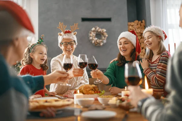 メリークリスマス幸せな家族は家で夕食を食べている ツリーの近くでお祝いの休日と団結 — ストック写真