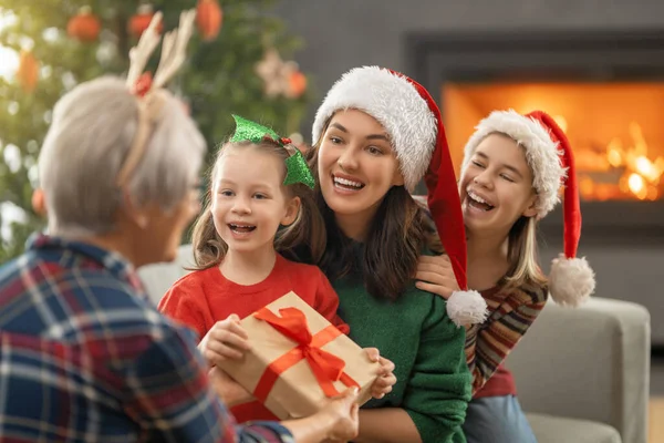 メリークリスマスとハッピーホリデー ママとおばあちゃんへの贈り物を提示する陽気な子供たち 屋内で木の近くで遊んでいる親と小さな子供たち プレゼント付きの家族を愛する — ストック写真