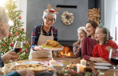 Mutlu noeller. Mutlu aile evde yemek yiyor. Kutlama tatili ve ağacın yakınındaki birliktelik.