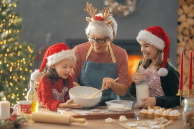 Mutlu Noeller ve mutlu tatiller. Aile hazırlığı bayram yemeği. Büyükanne ve torunları kurabiye pişiriyor..