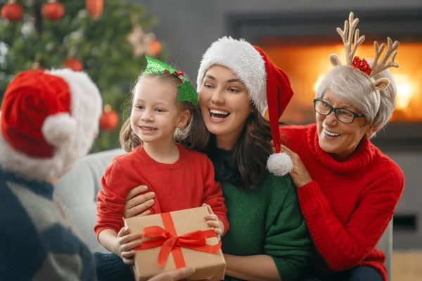メリークリスマスとハッピーホリデー おばあちゃん おじいちゃん お母さん 子供が贈り物を交換します 屋内で木の近くで遊んでいる両親と娘 プレゼント付きの家族を愛する — ストック写真