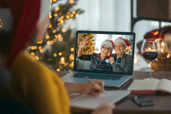 老两口在装饰过圣诞节的客厅里用笔记本电脑和他们的成年女儿聊天 — 图库照片