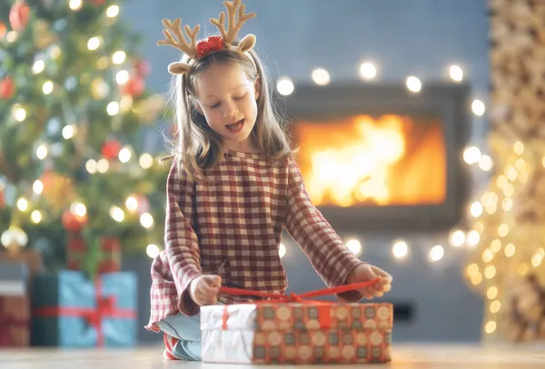 圣诞快乐 节日快乐 带着礼物快乐可爱的小女孩 小孩在树旁玩得很开心 — 图库照片