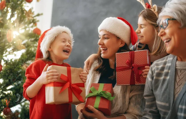 メリークリスマスとハッピーホリデー ママとおばあちゃんへの贈り物を提示する陽気な子供たち 屋内で木の近くで遊んでいる親と小さな子供たち プレゼント付きの家族を愛する — ストック写真
