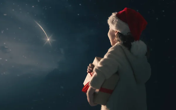 圣诞快乐 带着圣诞礼物的可爱的小孩 快乐的孩子望着流星许愿 黑暗天空背景下的天赋女孩的画像 — 图库照片