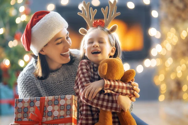 크리스마스 홀리데이 즐거운 어머니와 귀여운 선물을 교환한다 엄마와 아이들은 근처에서 — 스톡 사진