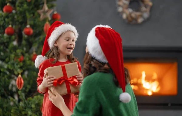 圣诞快乐 节日快乐 快乐的妈妈和她可爱的女儿交换礼物 妈妈和小孩在室内的树上玩得很开心 有礼物在房间里的爱的家庭 — 图库照片