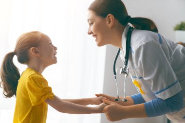 Dünya Çocuk Kanser Günü. Doktor muayenehanesindeki bir doktoru dinleyen kız hasta.. 