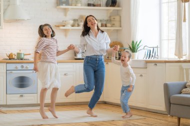 Anne ve kızları çocuklar dans ediyor. Aile tatili ve birliktelik.