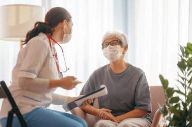 Coronavirus ve grip salgını sırasında maske takan doktor ve son sınıf öğrencisi. Virüs koruması. COVID-2019. Maske takıyor.