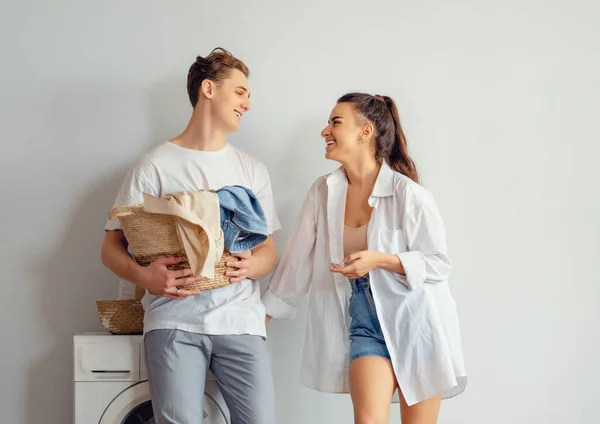 Bonito Jovem Casal Amoroso Está Sorrindo Enquanto Lavava Roupa Casa — Fotografia de Stock