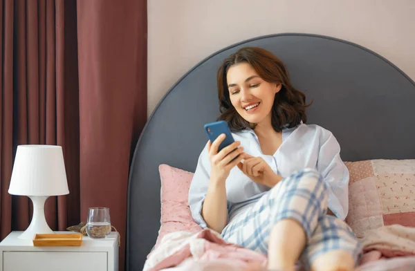 Feliz Casual Bela Mulher Está Usando Telefone Sentado Uma Cama — Fotografia de Stock