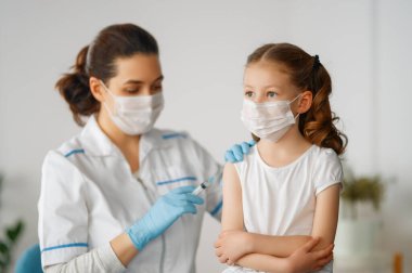 Hastanede çocuk aşılayan doktor..