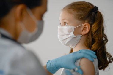 Hastanede çocuk aşılayan doktor..