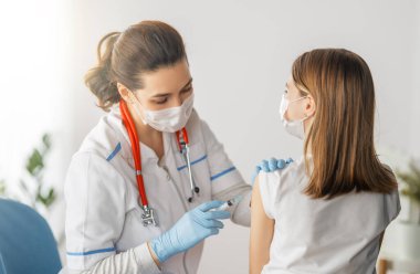 Hastanede çocuk aşılayan doktor..