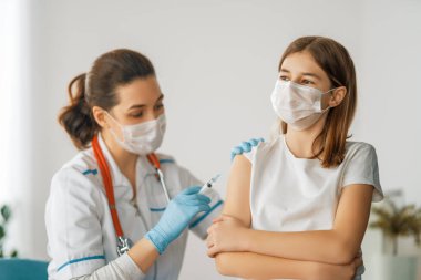 Hastanede çocuk aşılayan doktor..