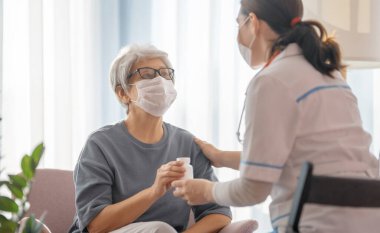 Coronavirus ve grip salgını sırasında maske takan doktor ve son sınıf öğrencisi. Virüs koruması. COVID-2019. Maske takıyor.