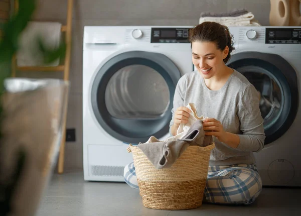 Hermosa Joven Mujer Sonríe Mientras Hace Colada Casa — Foto de Stock