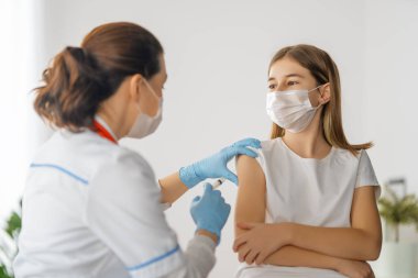 Hastanede çocuk aşılayan doktor..