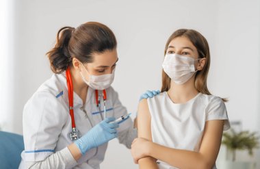 Hastanede çocuk aşılayan doktor..