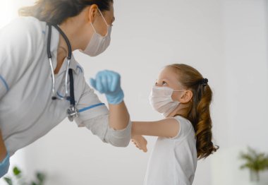 Doktor ve çocuk koronavirüs ve grip salgını sırasında maske takıyor. Virüs koruması. COVID-2019. Maske takıyor.