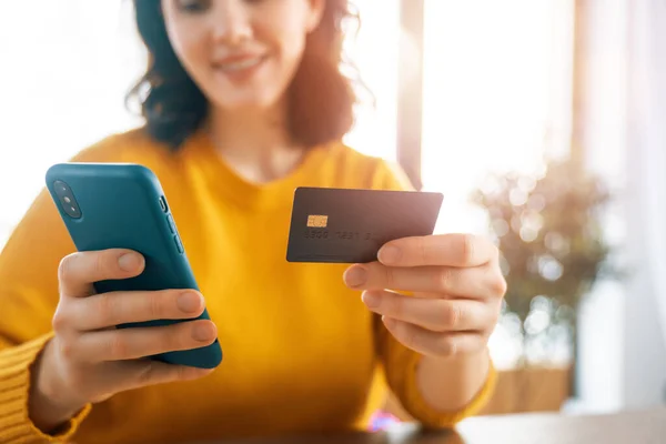 여성들은 온라인 구매를 있습니다 소녀는 집에서 전화와 카드를 사용하여 쇼핑을 — 스톡 사진
