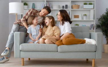 Mutlu aile! Anne ve babadan iki kız çocuğu. Annem, babam ve kızlar gülüyor ve sarılıyorlar..
